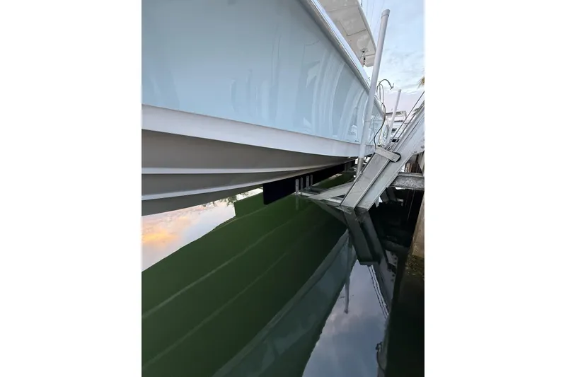 Slide: The Image of 2023 Boston Whaler 380 Outrage boat hull reflected in calm water. - 21