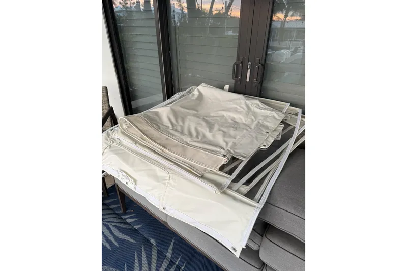 Slide: The Image of Folded boat covers for 2023 Boston Whaler 380 Outrage on a patio table. - 23