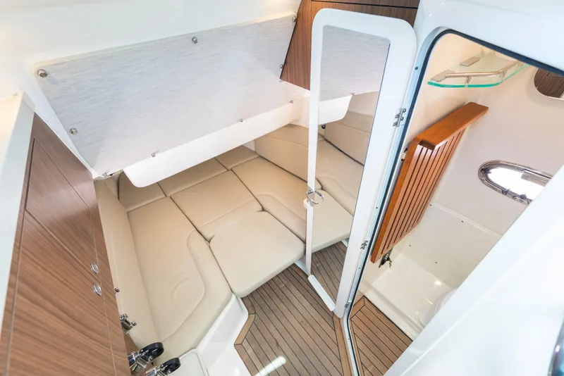 Slide: The Image of Interior cabin of 2020 Boston Whaler 380 Outrage with beige seating and wood accents. - 38