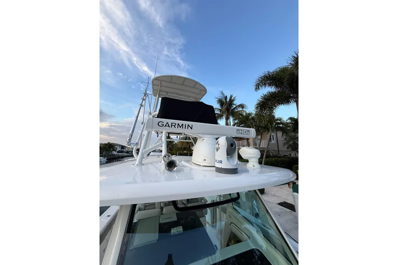 Slide: The Image of 2023 Boston Whaler 380 Outrage with Garmin equipment, docked near palm trees. - 4