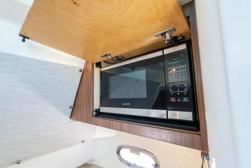 Slide: The Image of Microwave in 2020 Boston Whaler 380 Outrage boat's cabin, with wooden cabinetry. - 41