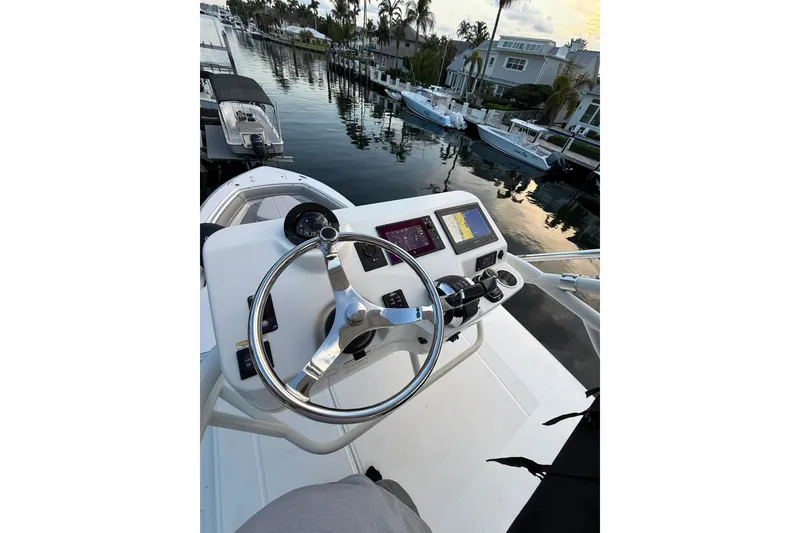 Slide: The Image of 2023 Boston Whaler 380 Outrage helm with modern controls and waterfront view. - 5