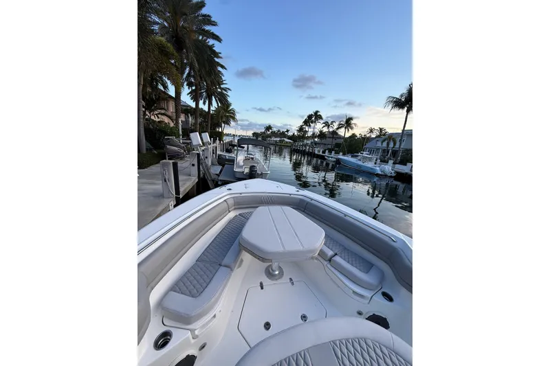 Slide: The Image of 2023 Boston Whaler 380 Outrage boat docked by palm trees at sunset. - 9