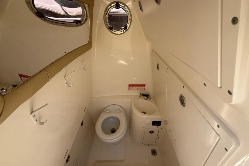 Slide: The Image of 2019 Key West Billistic 281 Center Console boat interior with toilet and sink. - 104