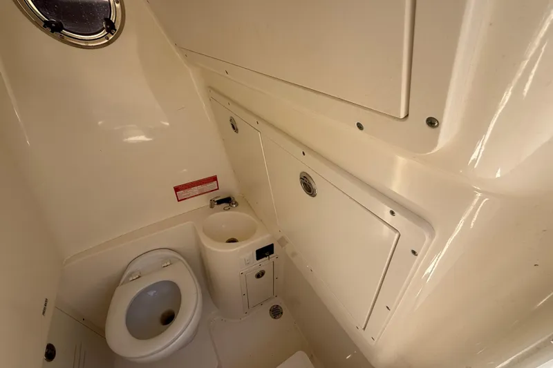 Slide: The Image of Interior of 2019 Key West Billistic 281 Center Console boat bathroom with toilet and sink. - 105