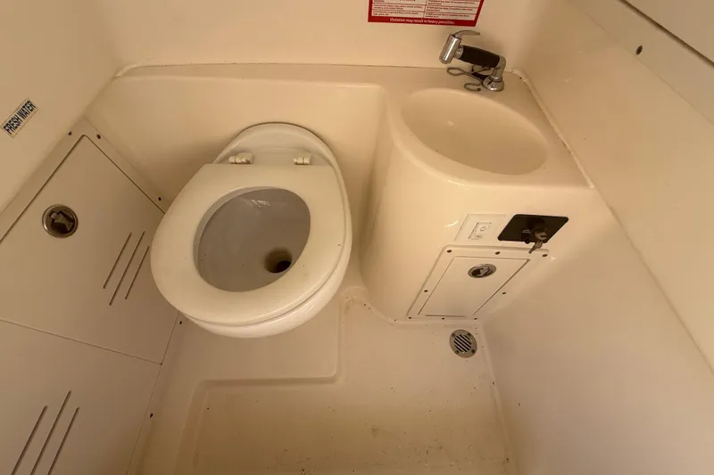 Slide: The Image of 2019 Key West Billistic 281 Center Console boat bathroom with toilet and sink. - 108