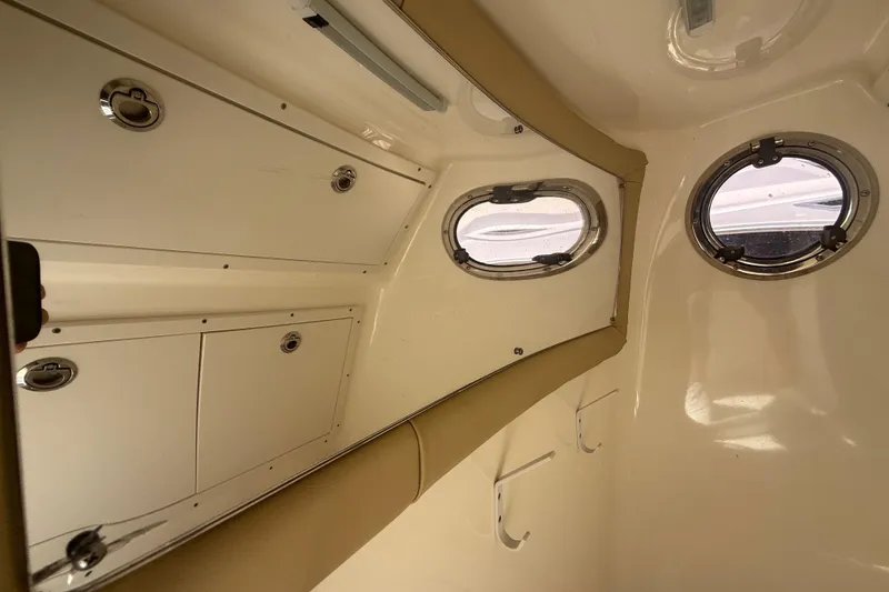 Slide: The Image of Interior cabin of 2019 Key West Billistic 281 Center Console boat with portholes and storage. - 109