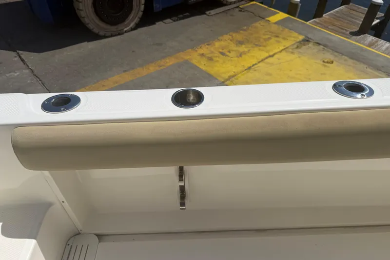 Slide: The Image of 2019 Key West Billistic 281 Center Console boat interior with rod holders and cushioned rail. - 125