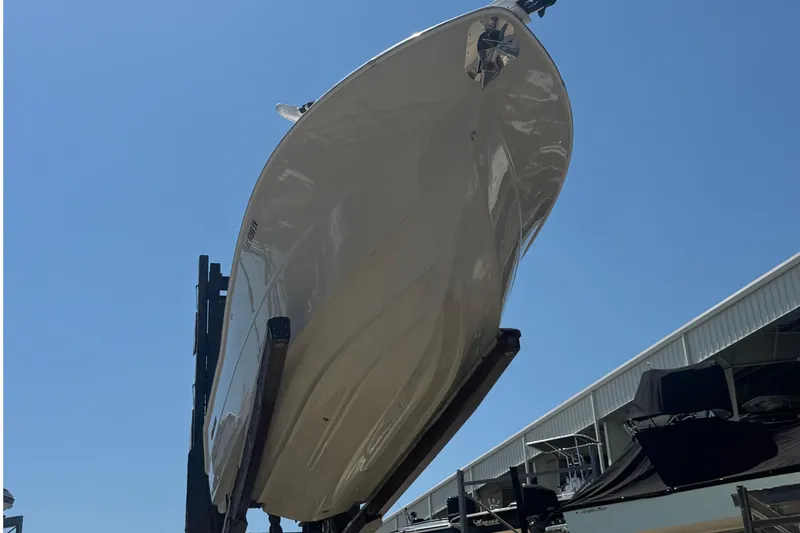 Slide: The Image of 2019 Key West Billistic 281 Center Console boat on lift under clear blue sky. - 13