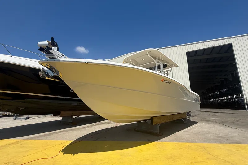 Slide: The Image of 2019 Key West Billistic 281 Center Console boat on display outside a warehouse. - 2