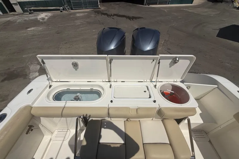 Slide: The Image of 2019 Key West Billistic 281 Center Console boat with open storage compartments and twin engines. - 34