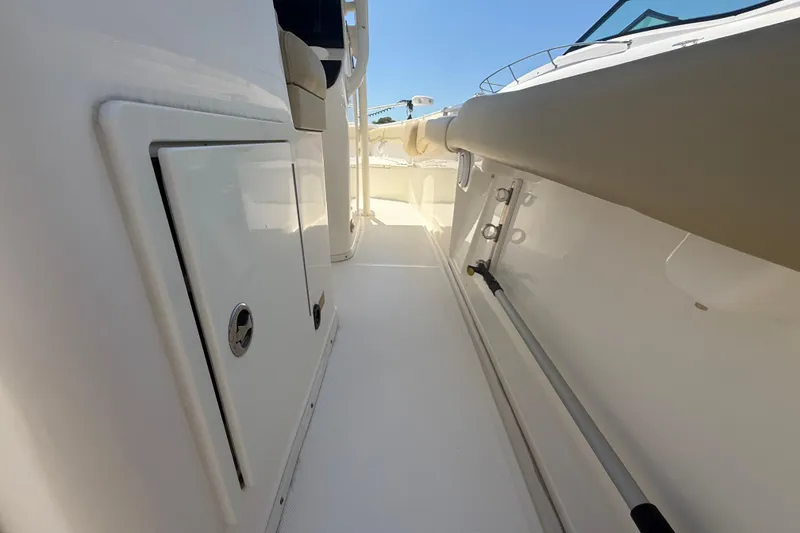 Slide: The Image of 2019 Key West Billistic 281 Center Console boat interior, featuring sleek white surfaces and storage compartments. - 44