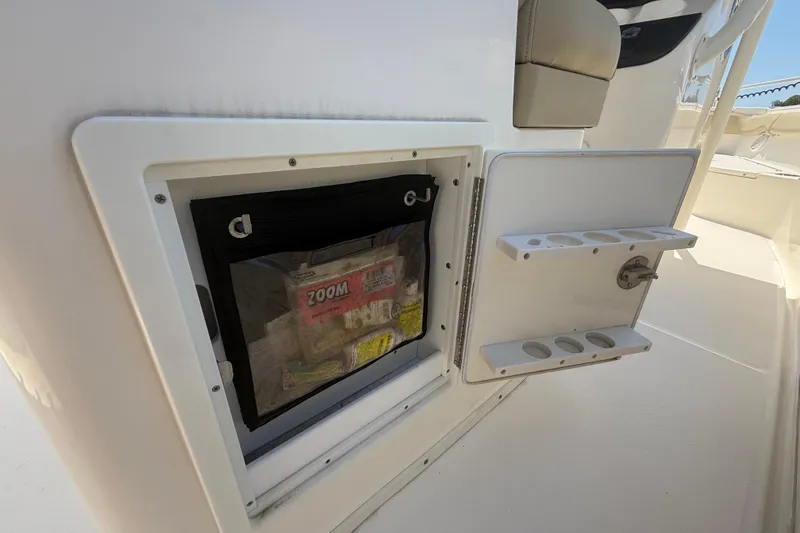 Slide: The Image of 2019 Key West Billistic 281 Center Console storage compartment with open hatch and tackle storage. - 47