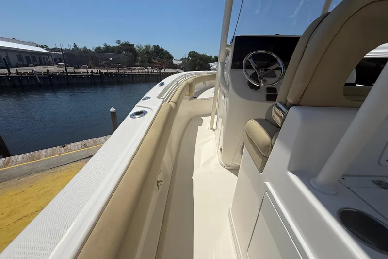 Slide: The Image of 2019 Key West Billistic 281 Center Console boat docked by a calm waterfront. - 49