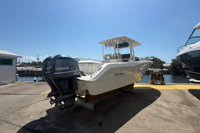 Slide: The Image of 2019 Key West Billistic 281 Center Console boat with Yamaha engines docked by the water. - 9