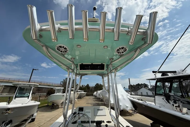 Slide: The Image of 2020 Carolina Skiff 26 Ultra Elite boat with rod holders and speakers under a blue sky. - 18