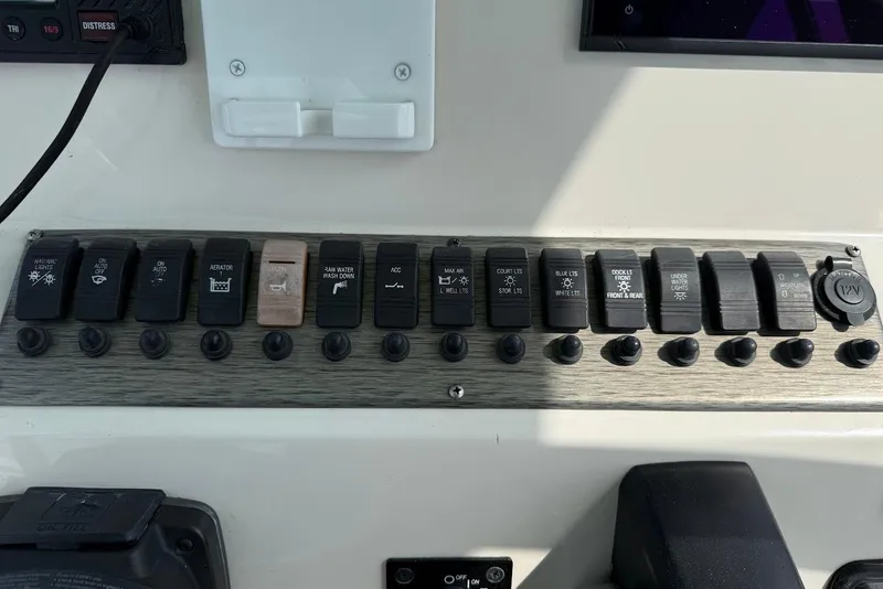 Slide: The Image of Control panel of a 2020 Carolina Skiff 26 Ultra Elite boat with labeled switches. - 22