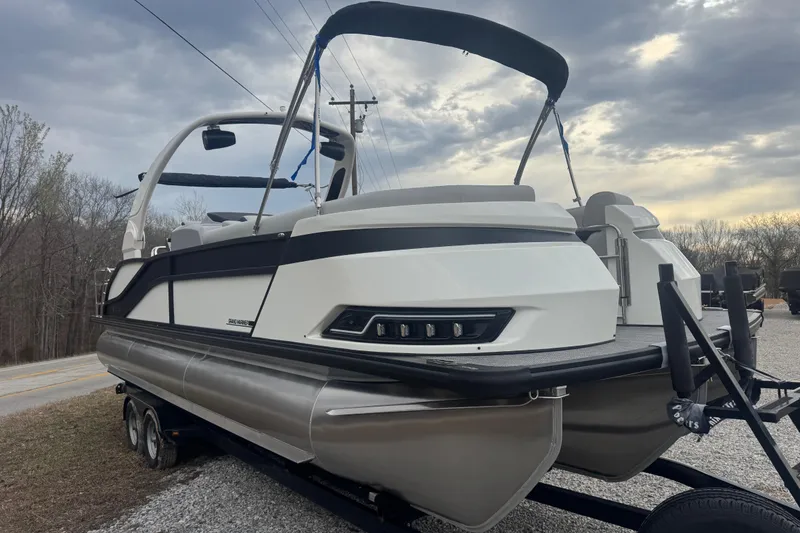 Slide: The Image of 2026 Harris Grand Mariner 250 SLDH pontoon boat on trailer under cloudy sky. - 3