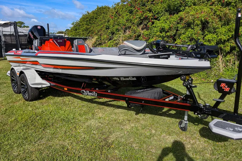 Slide: The Image of 2026 Bass Cat Lynx STS boat on trailer, parked on grass, with Garmin equipment. - 13