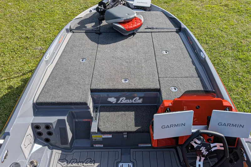 Slide: The Image of 2026 Bass Cat Lynx STS boat interior with Garmin electronics on grassy background. - 18
