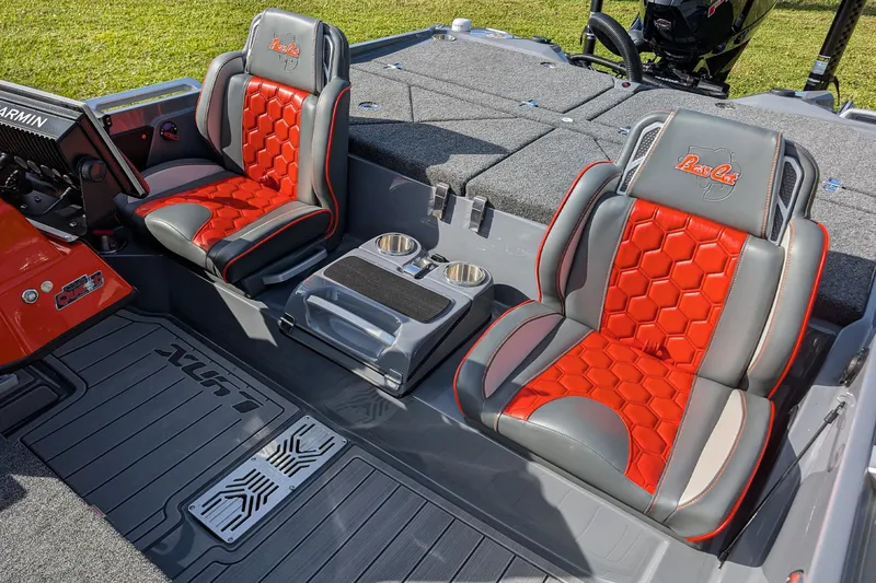 Slide: The Image of 2026 Bass Cat Lynx STS boat interior with red and gray seats, cup holders, and Garmin equipment. - 21