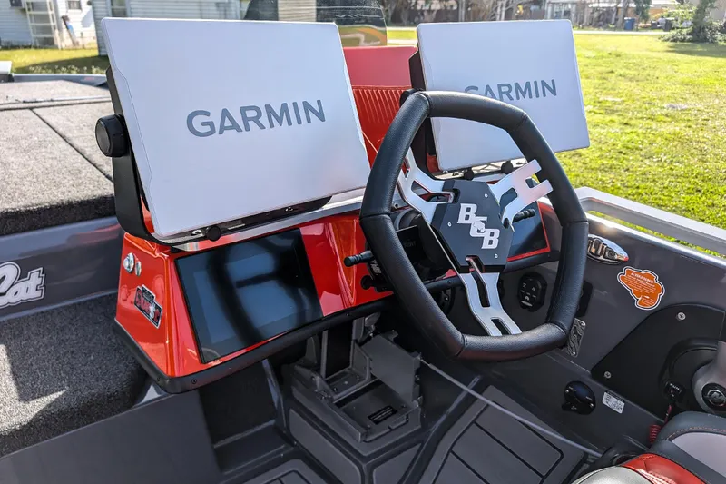 Slide: The Image of 2026 Bass Cat Lynx STS boat dashboard with Garmin displays and steering wheel. - 24