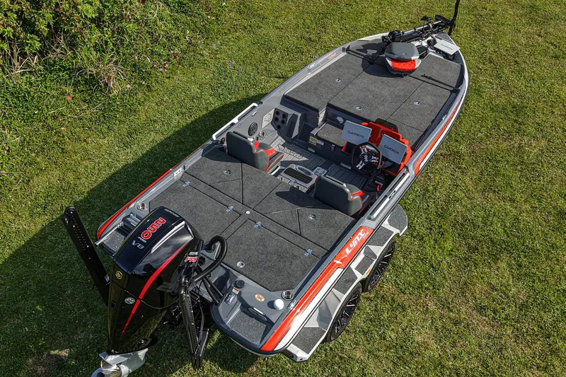 Slide: The Image of 2026 Bass Cat Lynx STS fishing boat on grass, featuring advanced Garmin electronics. - 27