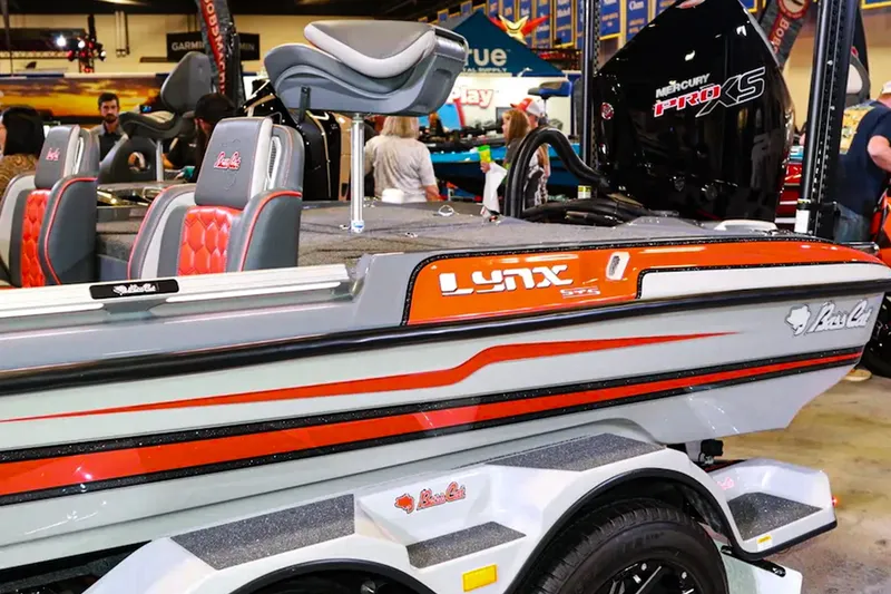 Slide: The Image of 2026 Bass Cat Lynx STS boat with red accents on display indoors. - 9
