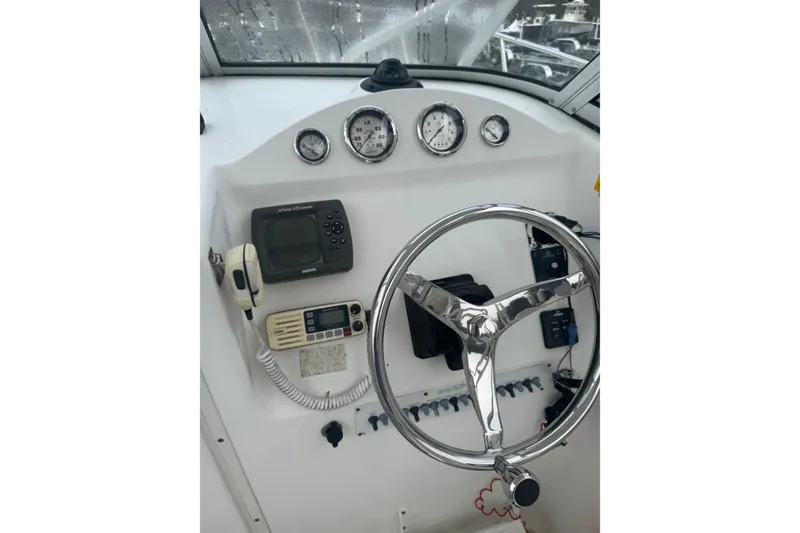 Slide: The Image of 2007 Sea Fox 236 Walk Around boat dashboard with steering wheel and navigation instruments. - 10
