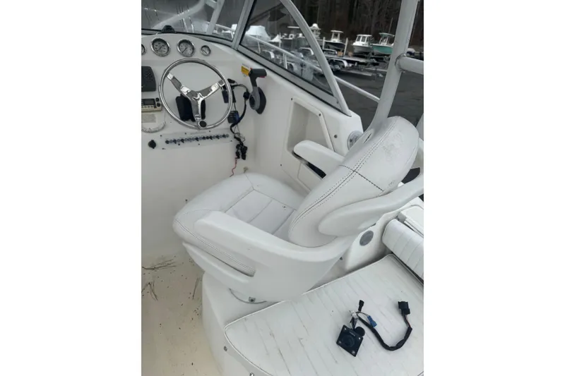 Slide: The Image of 2007 Sea Fox 236 Walk Around boat cockpit with steering wheel and white captain's chair. - 7