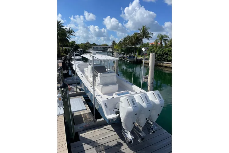 Slide: The Image of 2024 Invincible 36 Open Fisherman boat docked, featuring triple outboard engines, under a clear blue sky. - 1
