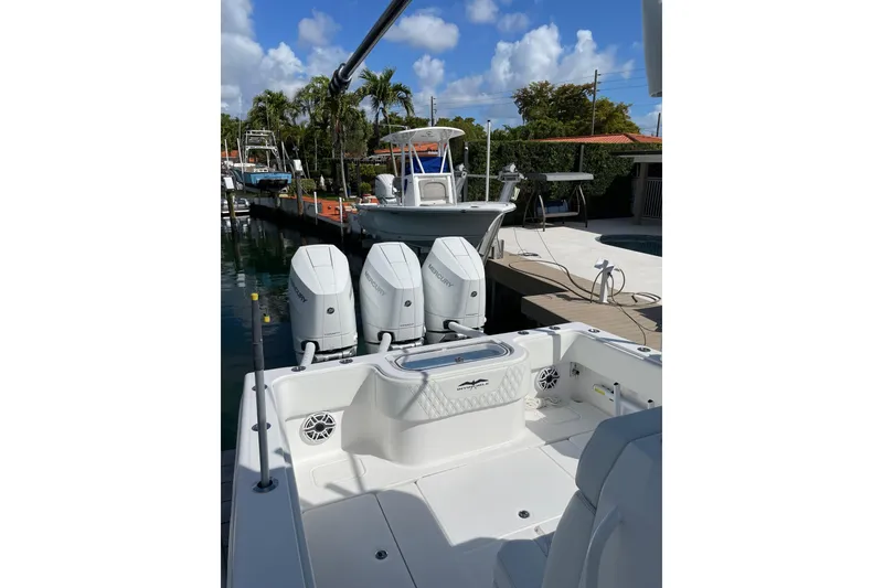 Slide: The Image of 2024 Invincible 36 Open Fisherman boat with triple Mercury engines docked under blue skies. - 15