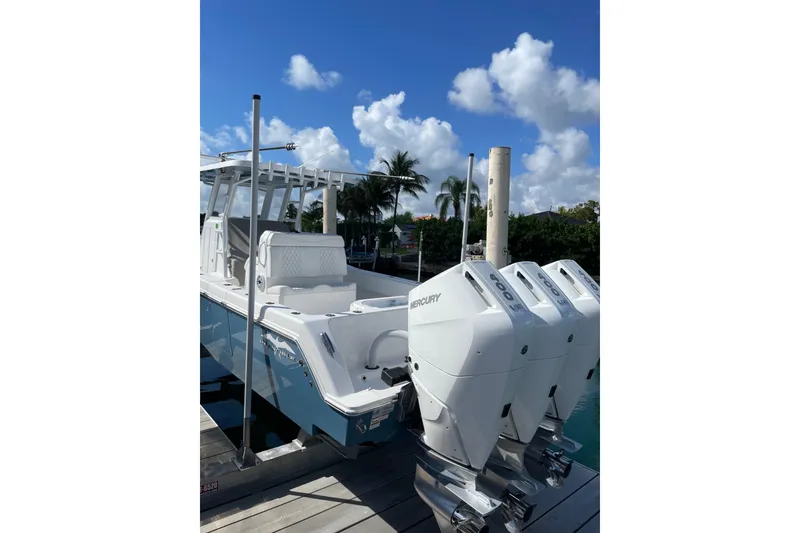 Slide: The Image of 2024 Invincible 36 Open Fisherman boat with triple Mercury engines docked under blue sky. - 32