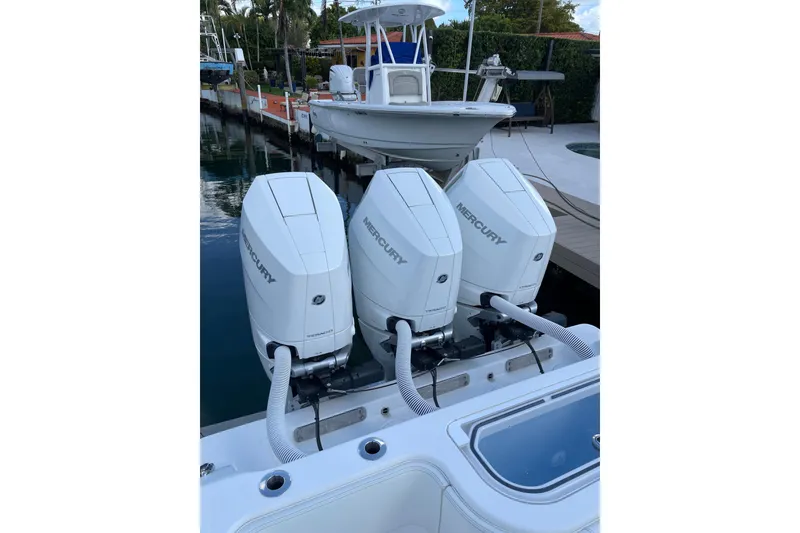 Slide: The Image of 2024 Invincible 36 Open Fisherman with triple Mercury outboard engines docked by the water. - 33