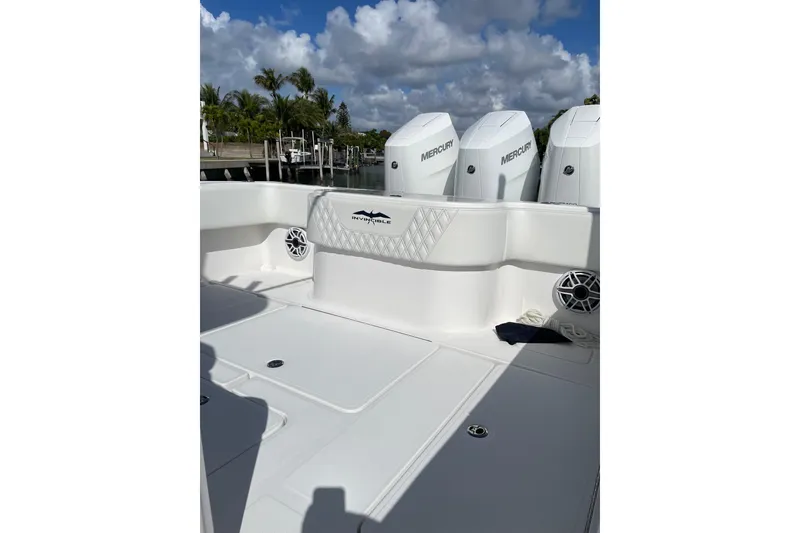 Slide: The Image of 2024 Invincible 36 Open Fisherman boat with Mercury engines, docked under a cloudy sky. - 5