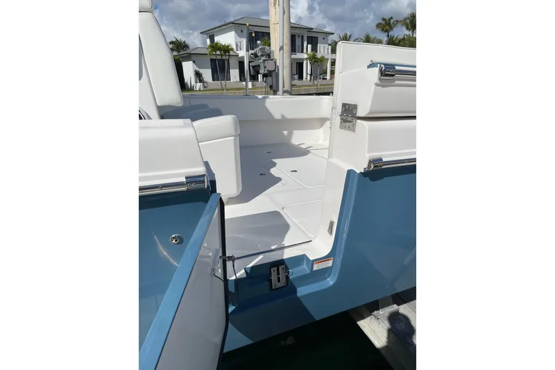 Slide: The Image of 2024 Invincible 36 Open Fisherman boat interior with open door, white seating, and blue exterior. - 6