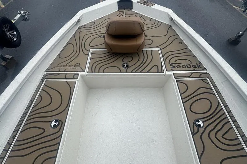 Slide: The Image of 2026 Xpress H22 boat deck with SeaDek flooring and brown seat. - 14