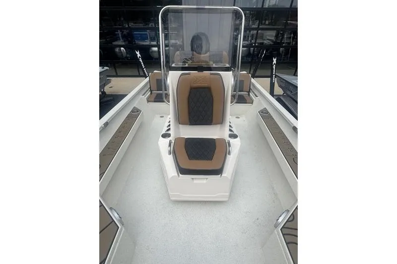 Slide: The Image of 2026 Xpress H22 boat interior with brown and black seating, clear windshield. - 18