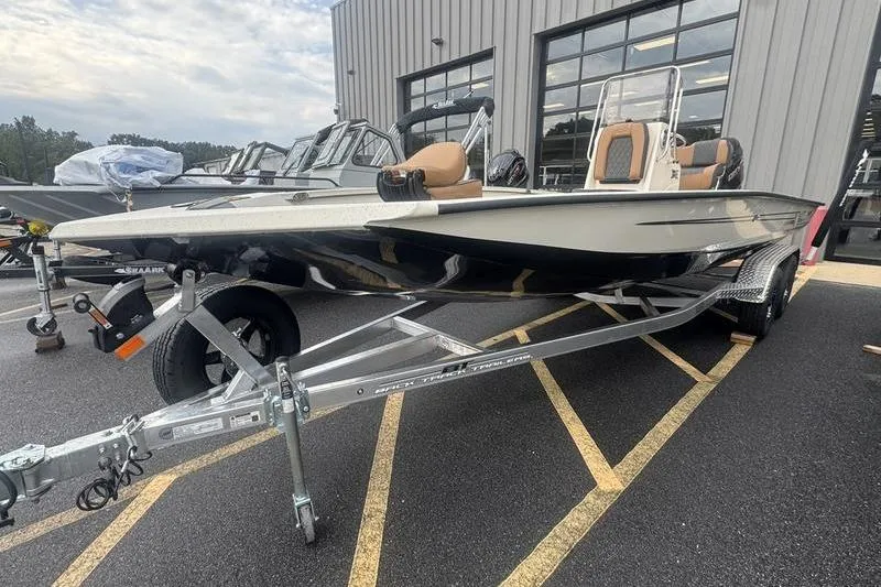 Slide: The Image of 2026 Xpress H22 boat on trailer, parked outside a showroom. - 7