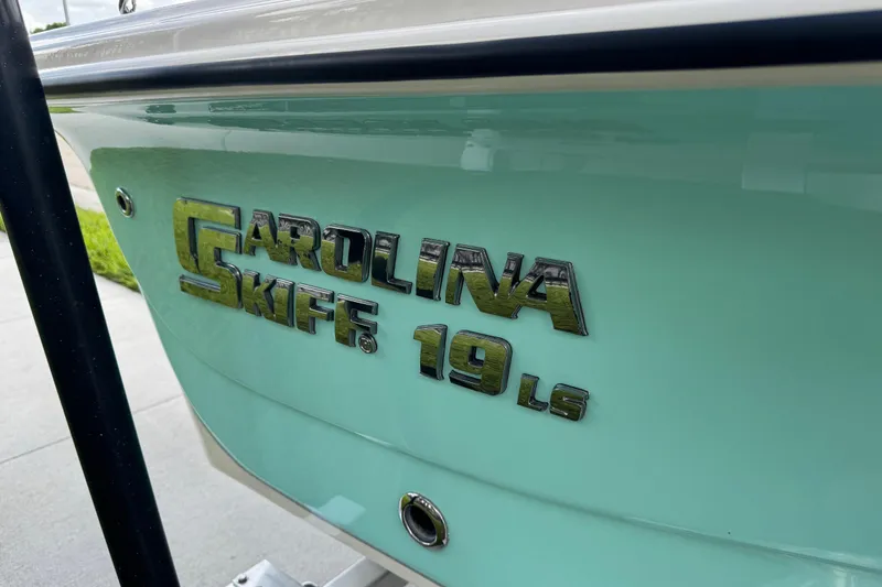 Slide: The Image of 2022 Carolina Skiff 19 LS boat with logo on light blue hull. - 17