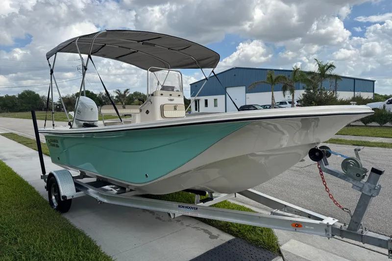 Slide: The Image of 2022 Carolina Skiff 19 LS boat on trailer, parked outdoors under cloudy sky. - 18