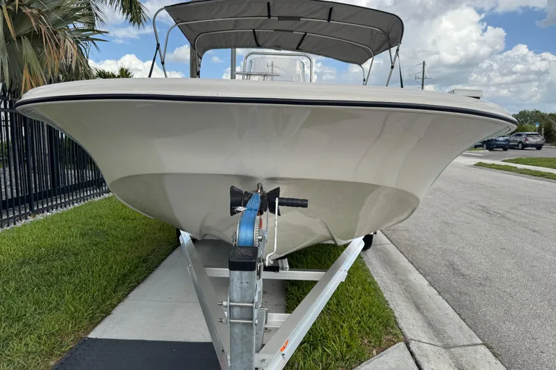 Slide: The Image of 2022 Carolina Skiff 19 LS boat on trailer, parked on roadside with palm trees. - 19