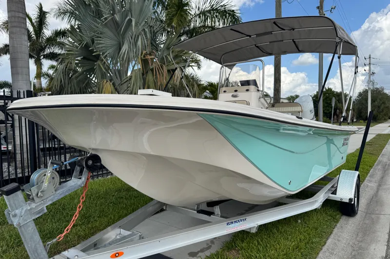 Slide: The Image of 2022 Carolina Skiff 19 LS boat on trailer, parked near palm trees. - 20