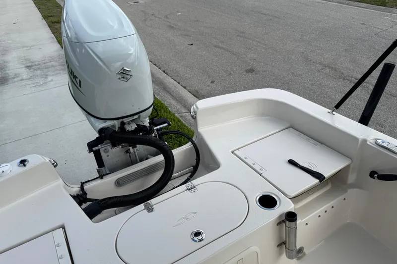 Slide: The Image of 2022 Carolina Skiff 19 LS boat with Suzuki outboard motor, docked on a street. - 23