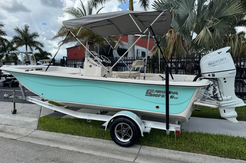 Slide: The Image of 2022 Carolina Skiff 19 LS boat with Suzuki outboard motor, parked on a trailer. - 3