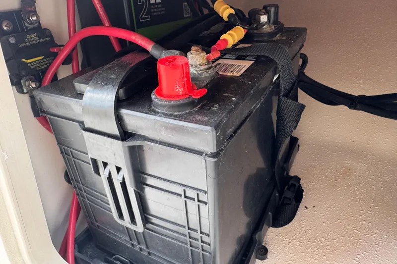 Slide: The Image of Battery compartment of a 2022 Carolina Skiff 19 LS boat with red and black cables. - 61