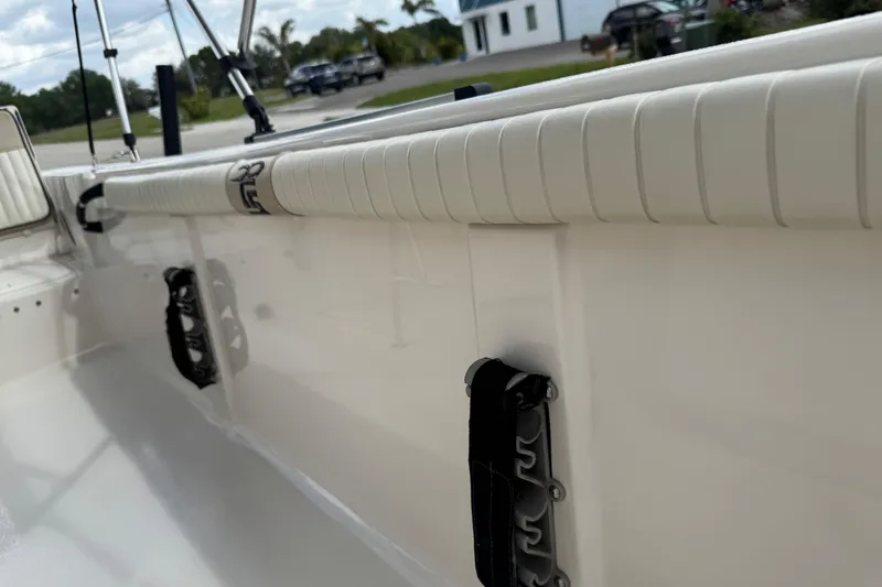 Slide: The Image of 2022 Carolina Skiff 19 LS interior detail with rod holders and cushioned rail. - 74