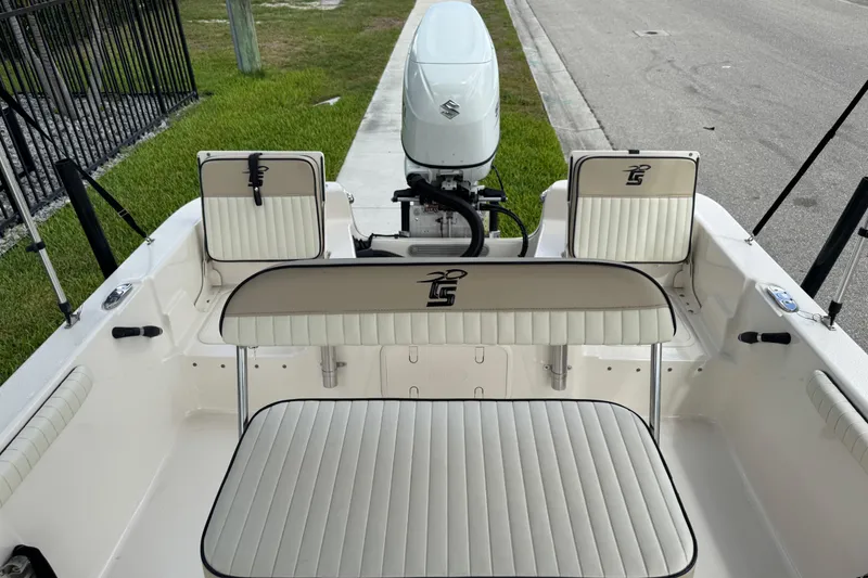 Slide: The Image of 2022 Carolina Skiff 19 LS boat interior with seating and motor, parked on roadside. - 76
