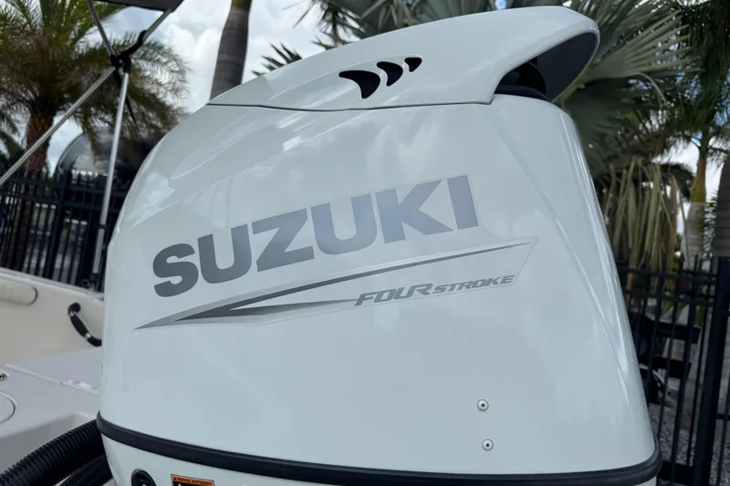 Slide: The Image of Suzuki four-stroke engine on 2022 Carolina Skiff 19 LS boat, palm trees in background. - 8