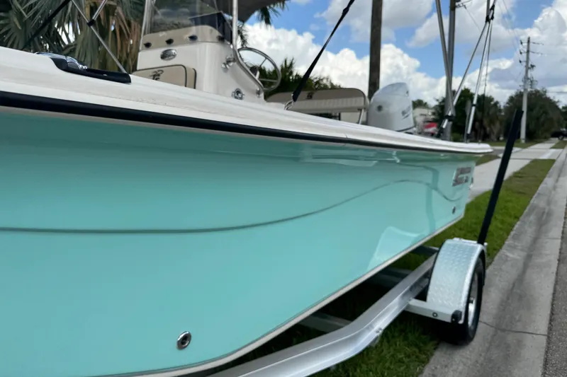 Slide: The Image of 2022 Carolina Skiff 19 LS boat on trailer, light blue hull, parked roadside. - 84